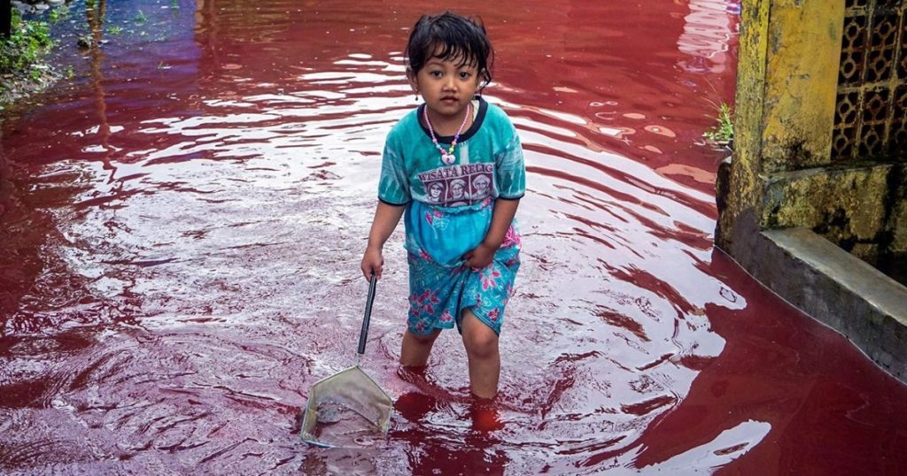 نهر باللون الاحمر يغمر قرية في اندونيسيا