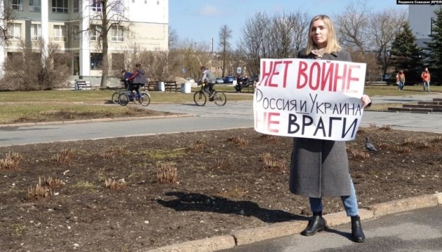امرأة روسية تخرج باعتصام فردي حاملة لافتة