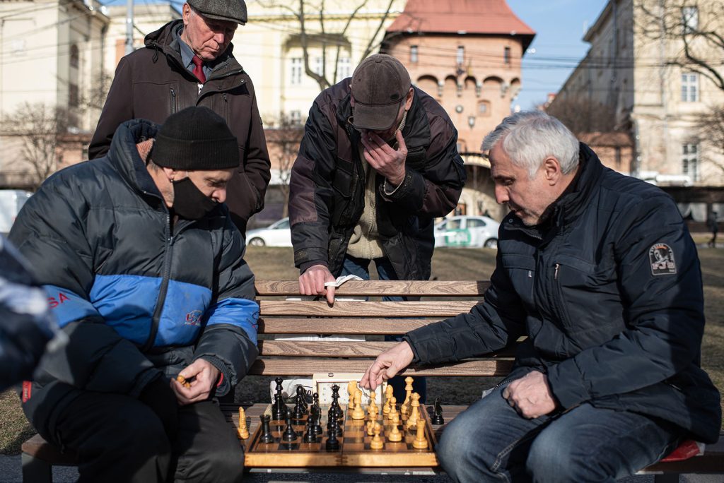رجال يلعبون الشطرنج على مقعد في الجادة المؤدية إلى دار الأوبرا في لفيف في 20 مارس